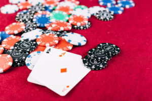 close-up colorful chips two aces playing cards poker table
